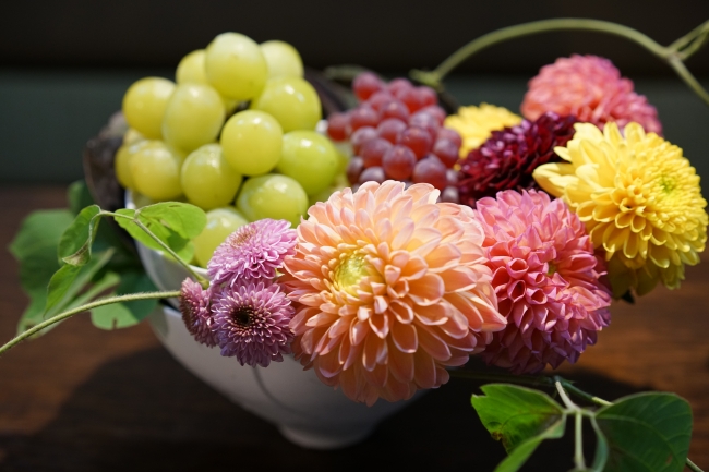 2枚の器を重ね器の間に花や葉をさしたアレンジ