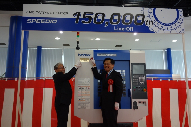 生産15万台目のSPEEDIOに記念銘板を取り付ける小池社長（右）と川那辺専務（左）