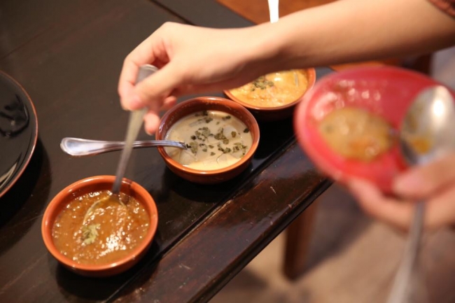 ［カレーのスパイスの配合を確認している様子］