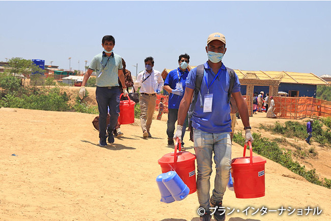 ロヒンギャ難民キャンプに予防キットを配布するプラン職員（バングラデシュ）