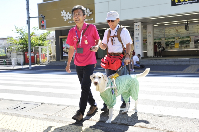 視覚障がいのあるお客さまに手引きをするサポーターとして参加する社員（実践型研修の様子）