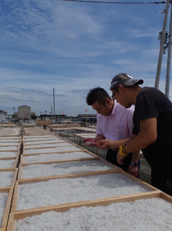 淡路島の加工場を訪れ、関係者㊨からゆで上げられたシラスについて説明を受ける田中総料理長㊧