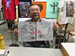 サイン色紙を持った開田裕治氏