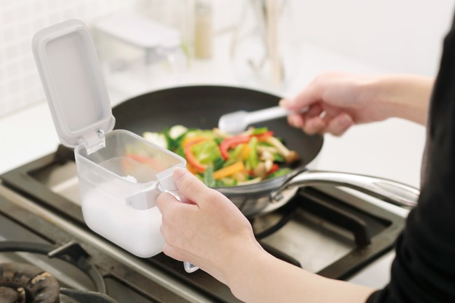 フタが奥に開くので容器を持ったまま片手ですくえる