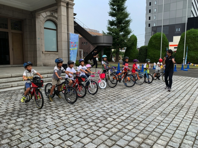 試乗を兼ねた実演、ピカピカ自転車に緊張の表情だ