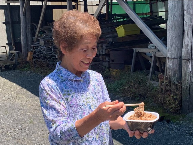 牛丼を受取り笑顔の村民