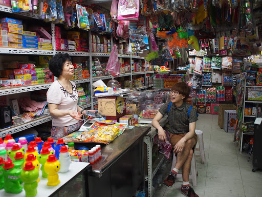 台湾の店内で店主と話す田中佑典氏。