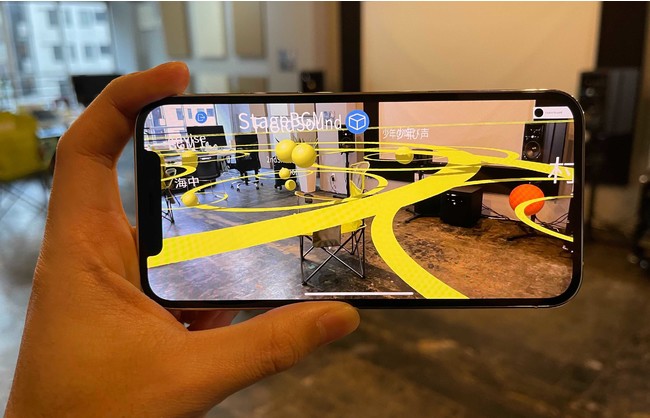 ＜『Auris』ゲーム編の起動イメージ ＞ スマートフォンのカメラをかざすと、実際に施設や空間などに配置・保存されているトリガーや音声を『Auris』上で確認できます。