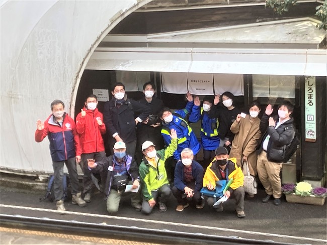 写真　沿線まるごとホテルの実証実験風景（活用した無人駅「白丸駅」でのプロジェクトメンバーの記念写真）