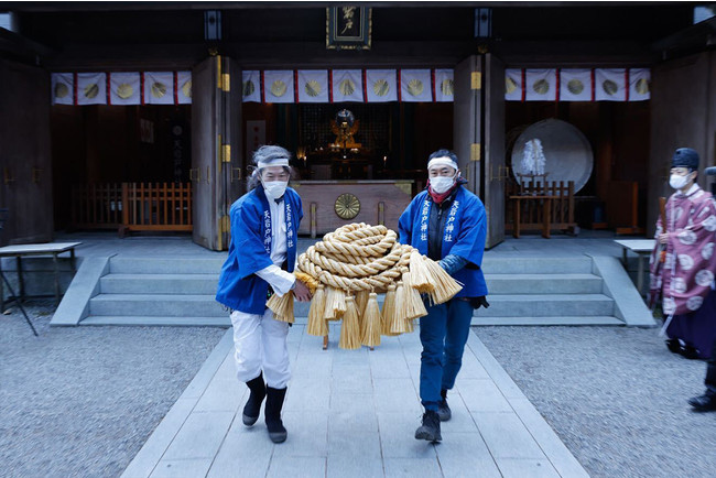 祈祷を終えた注連縄を運ぶ竹内洋岳（左）