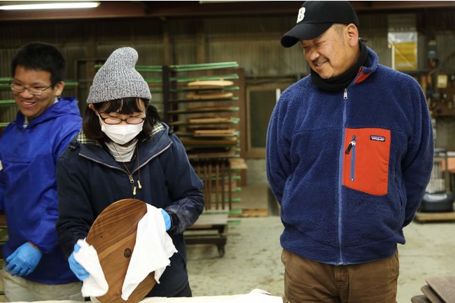 工場では若い女性職人も活躍している。右で微笑むのは伝統工芸株式会社 代表取締役 服巻俊彦さん。