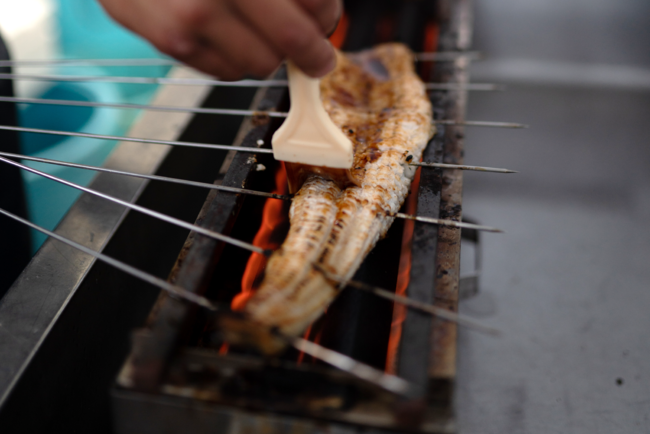 1本1本、丁寧に手捌き手焼きをしている