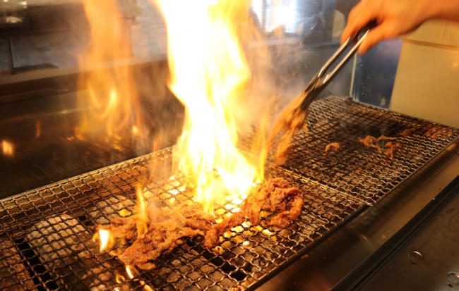 オープンキッチンでカルビを網焼き