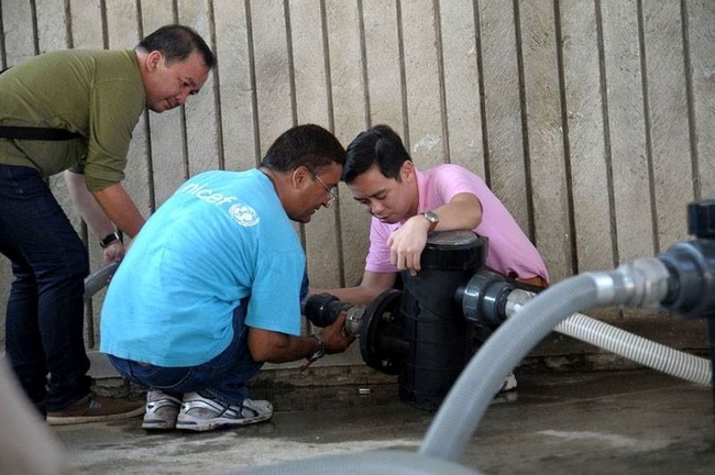 ©UNICEF Philippines/2013/Ivan Hibalo　台風で被災したカピス島で、水処理ユニットを設置するユニセフの水と衛生専門官と保健専門官