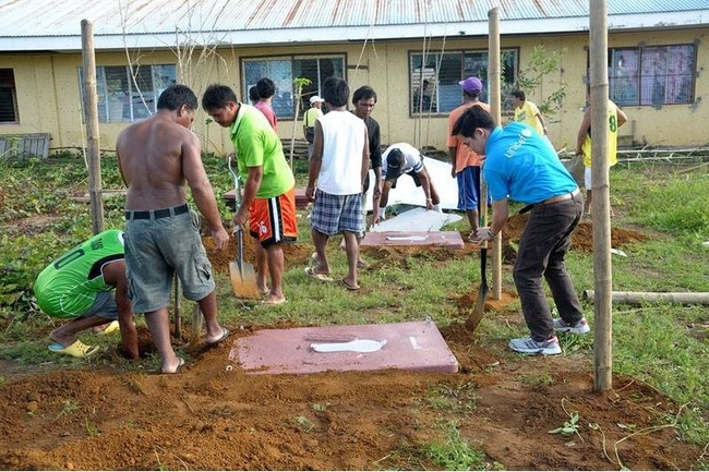 ©UNICEF Philippines/2013/Ivan Hibalo   カピス島ピラーの避難所で、一時的に使用できる簡易トイレを協力して作るユニセフ職員と地域ボランティア。