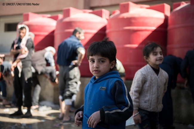 ユニセフが提供した貯水タンクの前に立つ男の子。(2018年3月20日撮影) © UNICEF_UN0187068_Nader 