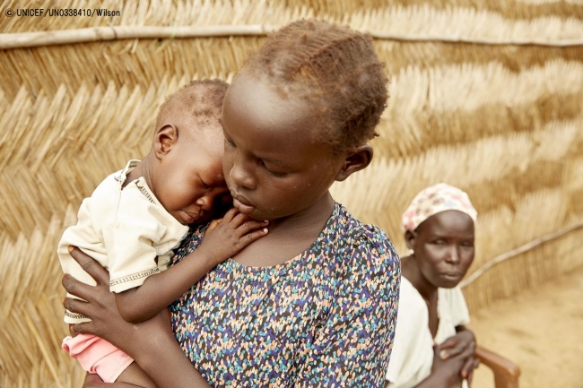 重度の急性栄養不良と診断された妹を抱く女の子。(2019年7月18日撮影) © UNICEF_UN0338410_Wilson