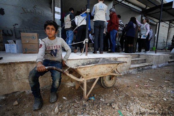 シンジャール村の食品流通センターで、食料の配給を待つ男の子。 © UNICEF_UNI308344_Sanadiki