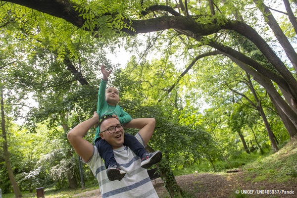 3歳の息子と外で遊ぶ父親。両親は、保護者向けの子育て支援プログラムを受けている。(セルビア、2021年4月撮影) © UNICEF_UN0465937_Pancic