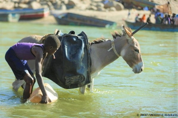 エチオピアとスーダンの間を流れる川で水を汲む男の子。(スーダン、2020年11月撮影) © UNICEF_UN0403214_Abdalkarim