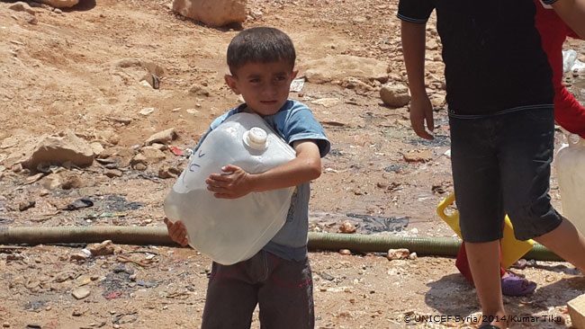 避難所の給水場所で長い間並んで汲んだ水を持ち帰る男の子© UNICEF Syria/2014/Kumar Tiku