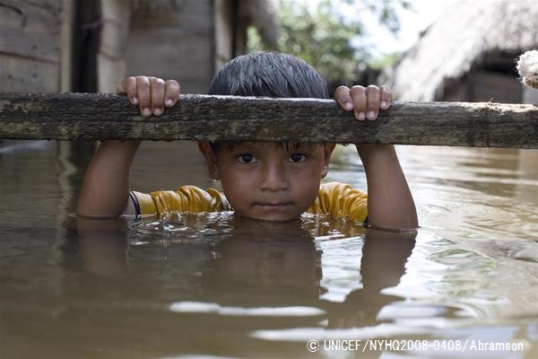 洪水で浸水した自宅の外の木枠につかまる男の子。（ボリビア）© UNICEF_NYHQ2008-0408_Abramson