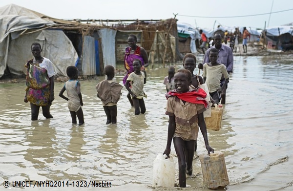 洪水に見舞われた避難所で、水を運ぶ子ども。（南スーダン）© UNICEF_NYHQ2014-1323_Nesbitt