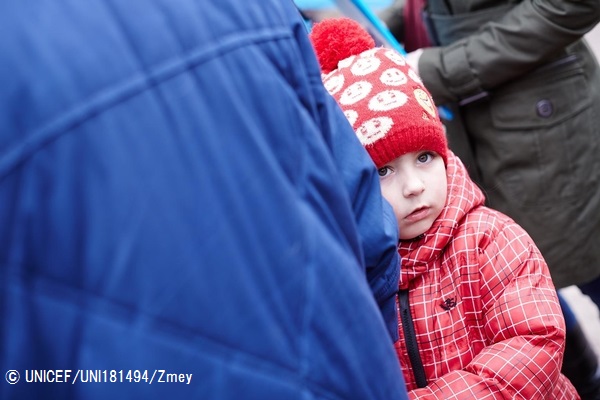 衛生物資を受け取る列に母親と並ぶ女の子。© UNICEF_UNI181494_Zmey