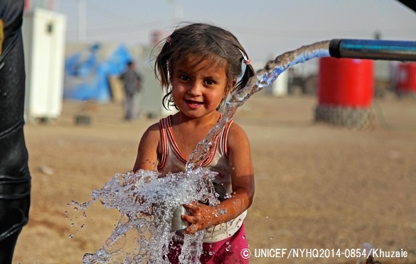 給水所でコップに水を汲む避難民キャンプで暮らす3歳の女の子。（イラク）© UNICEF_NYHQ2014-0854_Khuzaie