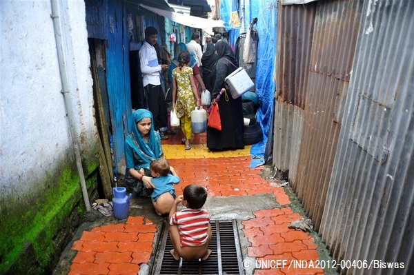 自宅にトイレがないため、子どもに排水溝で排泄させる母親。（インド）© UNICEF_INDA2012-00406_Biswas