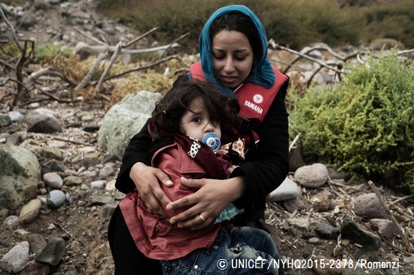 エーゲ海の北東部レスボス島の海岸で、幼い女の子を抱きしめるシリア出身の女性。© UNICEF_NYHQ2015-2378_Romenzi