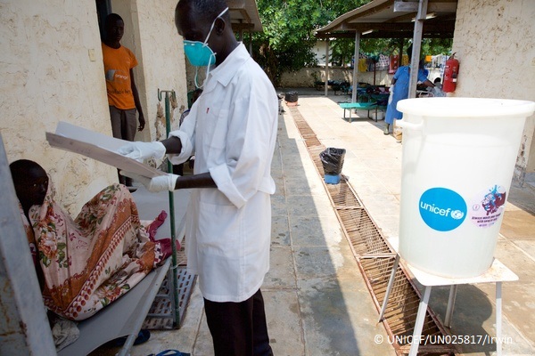 Juba Teaching 病院で簡易ベッドに横たわる人に話しかけるヘルスワーカー © UNICEF_UN025817_Irwin