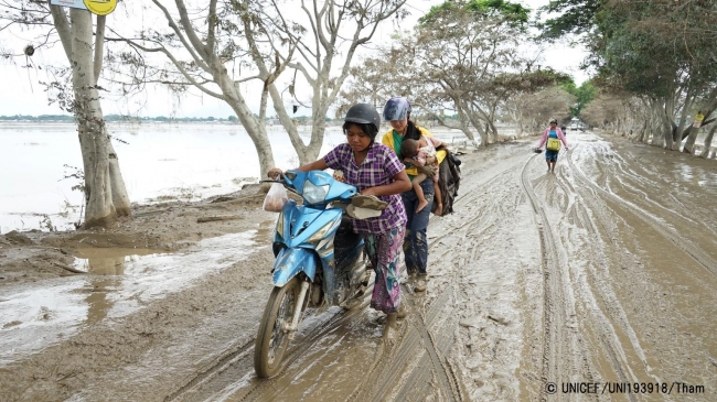 洪水の影響を受けた地域で、バイクを押す女性たち (ミャンマー・カレー郡) 2015年8月撮影　※本文との直接の関係はありません。© UNICEF_UNI193918_Thame