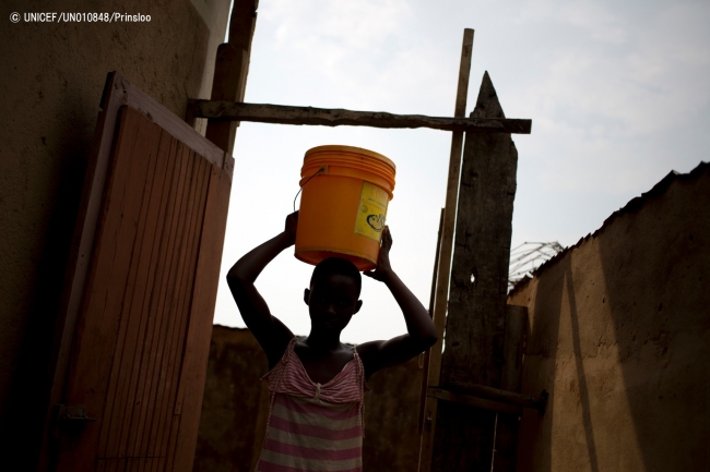 水に入ったバケツを運ぶ13歳の女の子(2016年2月撮影) © UNICEF_UN010848_Prinsloo