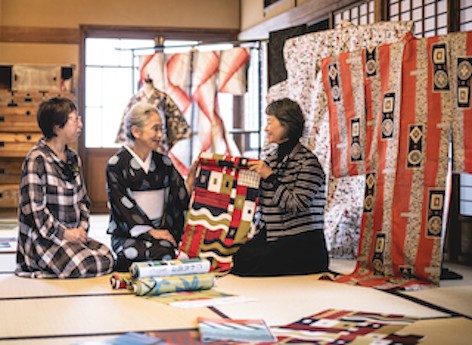 左より21 世紀銘仙プロジェクトで中⼼的役割を果た した⾦井珠代⽒、杉原みち⼦⽒、テキスタイルデザイ ナーの須藤玲⼦⽒。伊勢崎銘仙の貴重なコレクション を前に。Photo Kosuke Tamura