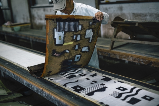 色の数だけ用意された型紙の位置をあわせながら染めていく。Photo Kosuke Tamura