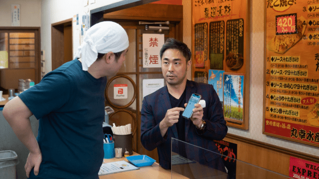 店舗で予約番号を確認する様子