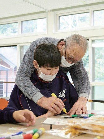 手書きのラベル作成を教わる学生