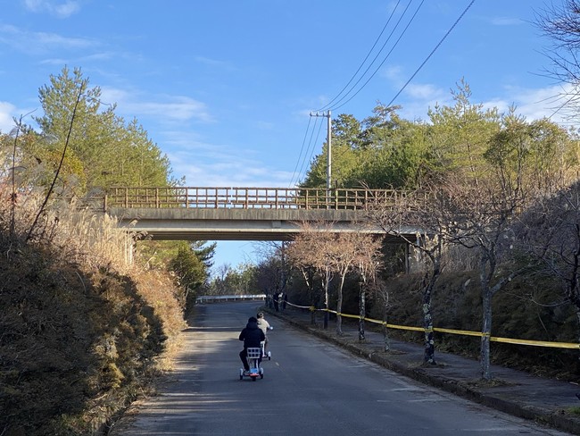 駐車場から電動バイクで坂上の観戦エリアまで試乗する参加者