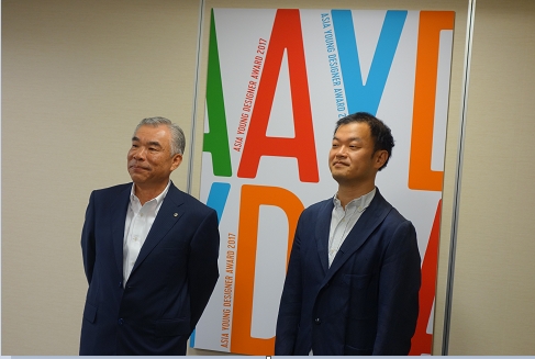 田堂社長・藤原氏　AYDAのポスター前にて