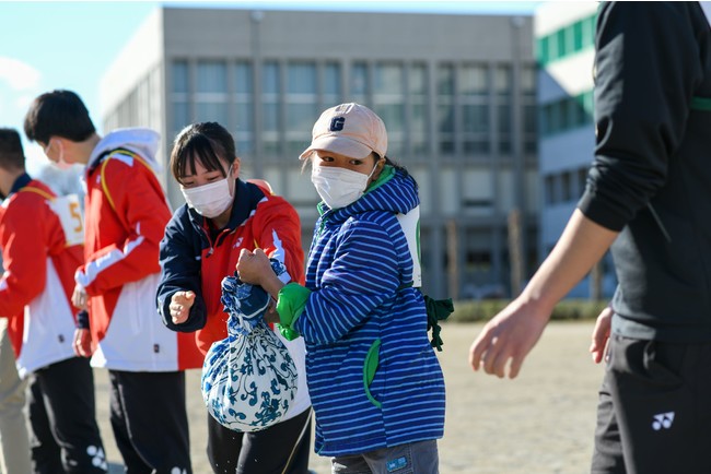 風呂敷バケツをリレーする参加者たち