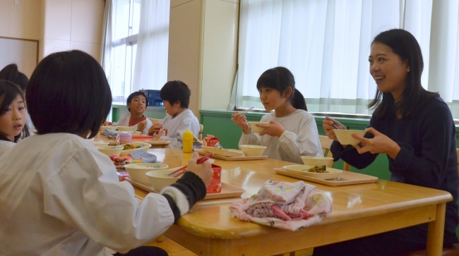 一緒に給食を楽しむ子どもたちと鈴木明子さん(右端)